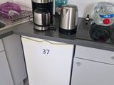 a small kitchen with a coffee maker on the counter