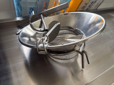 a stainless steel bowl with a strainer in it on a table