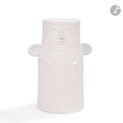 un vase blanc sur lequel est représenté un visage sur le côté