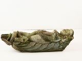 a statue of a man in a boat on a white surface