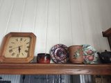 a shelf with a clock, vases, and other items on it