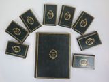 six books are arranged in a circle on a white surface