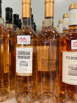 plusieurs bouteilles de vin sont alignées sur une étagère