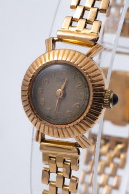 an image of a close up of a wrist watch on a clear surface