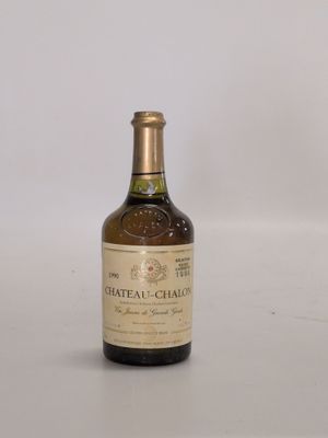 une vieille bouteille de vin posée sur une table blanche