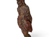 an old wooden statue of a man with a bird on his back
