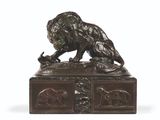 bronze statue of a lion on a pedestal with a bird in its mouth