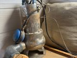 a metal water pump sitting on a table next to a window
