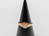 une bague en or et diamants posée sur un cône noir