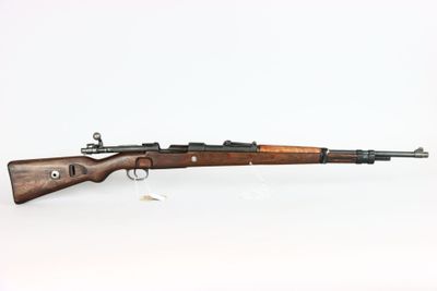 un fusil avec un canon en bois sur fond blanc