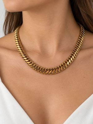 une femme portant un collier à chaîne en or et des boucles d'oreilles