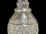 un vase en verre transparent avec un couvercle argenté, sur fond noir