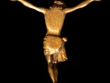 statue of jesus on the cross in the dark with a black background