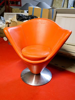 an orange chair that is sitting on a red floor