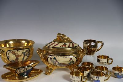 un service à thé doré, avec des tasses et des soucoupes, posé sur une table blanche