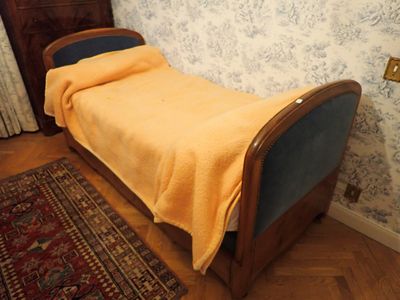 un lit recouvert d'une couverture jaune dans une chambre