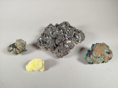 several different colored rocks are arranged on a white surface