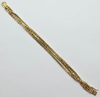 un bracelet en or muni d'une chaîne qui y est attachée
