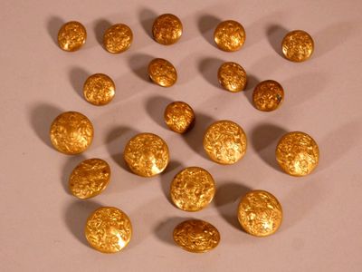 Des pépites d'or sont disposées en cercle sur une surface blanche