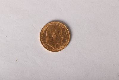 gros plan d'une pièce d'or sur une surface blanche