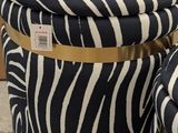 two zebra print stools with gold trim and a black and white zebra print cover