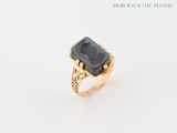 an image of a gold ring with a black stone in the center