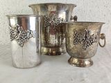 three silver vases sitting next to each other on a table