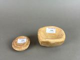 two small wooden bowls with labels on them sitting on a table