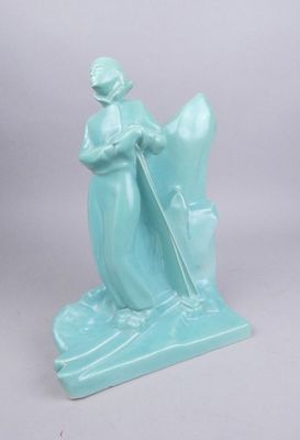 une figurine bleue représentant une femme avec un chapeau et une canne