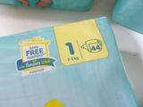 a package of diapers on a table next to a person