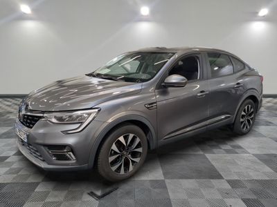 the grey car is parked on a checkered floor in a garage