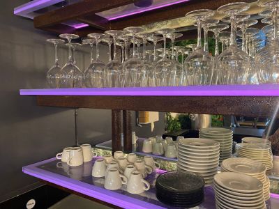 de nombreux verres et assiettes sur une étagère dans la cuisine