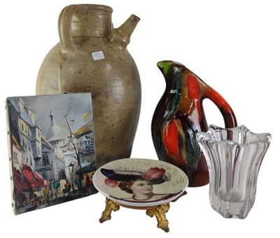 a vase, a plate, and a picture of a woman on a table