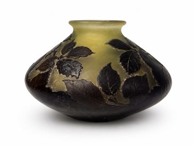 un vase noir et doré orné de feuilles