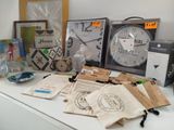 many items on a table that include a clock, a bag, and other items