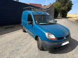 the blue van is parked in the parking lot near a building