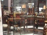 un miroir au milieu d'une pièce, avec une table et des chaises en arrière-plan
