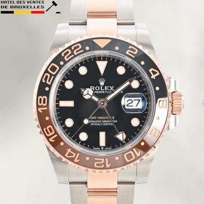 a rolex watch with a black dial and two tone bracelet