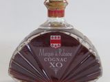 a bottle of cognac sitting on a white surface