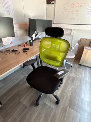 une chaise verte posée devant un bureau d'ordinateur