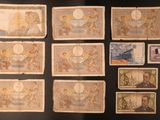 several different types of paper currency are displayed on a black surface