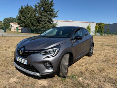 a grey car parked in a field with trees in the background