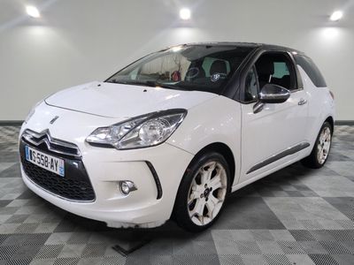 la petite voiture blanche est garée sur un sol en damier
