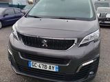La voiture grise est garée sur le parking, à côté d'autres voitures.