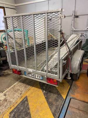 a trailer with a cage on the back of it in a garage