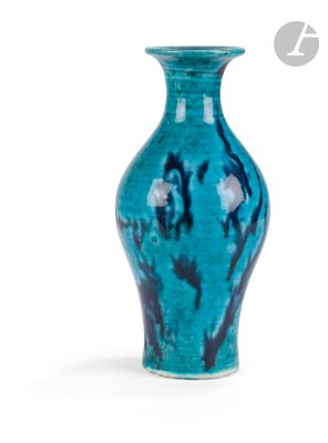 un vase bleu posé sur une surface blanche
