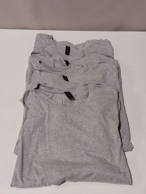 three pairs of grey t - shirts sitting on top of a white table
