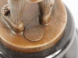 a bronze figurine of a woman holding a tennis racquet