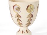 a white cup with a gold decoration on it