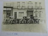 une photo montrant un groupe de voitures anciennes garées devant un immeuble
